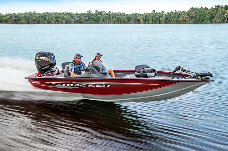 A man operates a bass boat on a lake